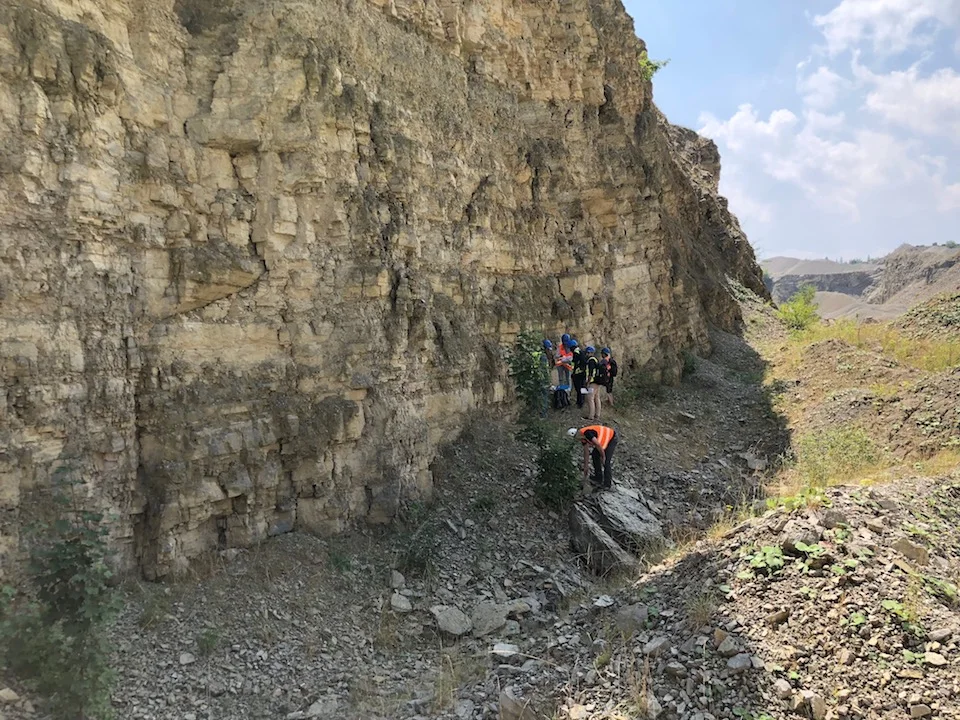 Students examining fractures at a limestone outcrop during a field course